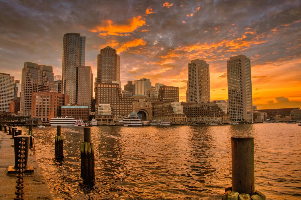 pexels photo 27062463 27062463 Stunning sunset over Boston's iconic skyline reflecting in the harbor waters.
